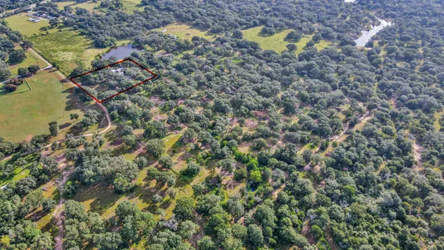 a aerial view of a house with a yard and a swimming pool