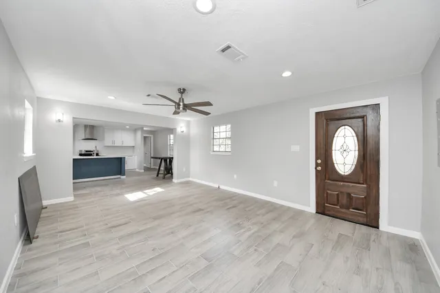 a view of an empty room with window and cabinet