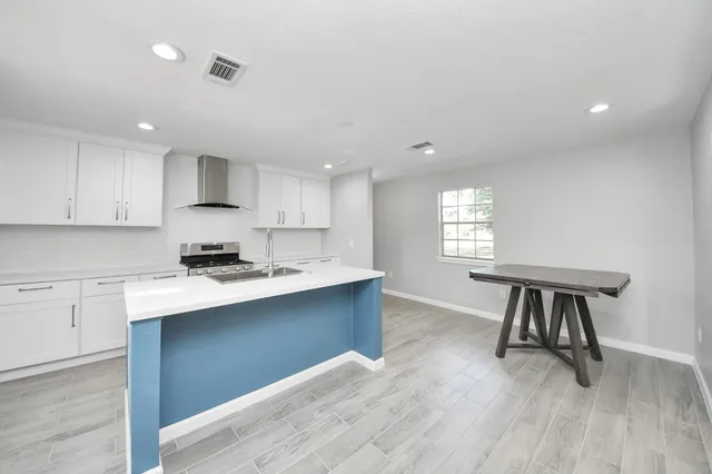 a kitchen with kitchen island a sink stainless steel appliances and cabinets