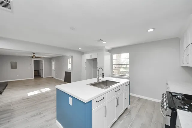 a kitchen with a sink stove and cabinets