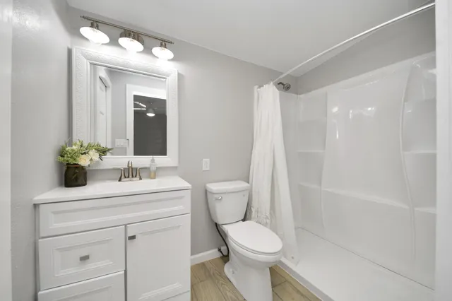 a bathroom with a sink a toilet and shower