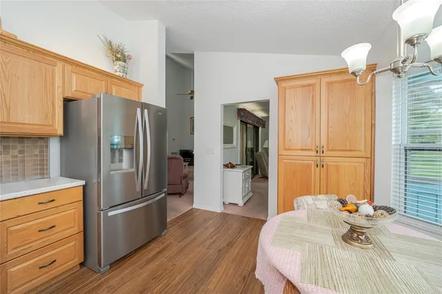 a kitchen with stainless steel appliances a refrigerator and a wooden floor
