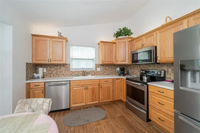 a kitchen with granite countertop a sink stove and wooden cabinets