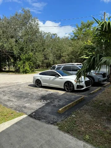 a view of a backyard with a car parked on the road