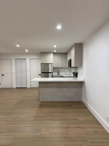 a view living room with stainless steel appliances kitchen island sink refrigerator and stove