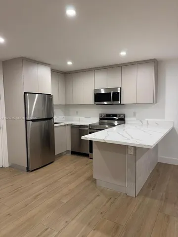 a kitchen with kitchen island a refrigerator sink and microwave
