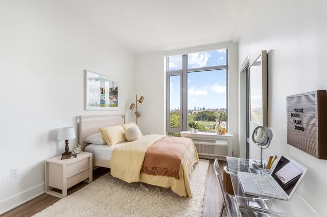 a spacious bedroom with a bed and a large window