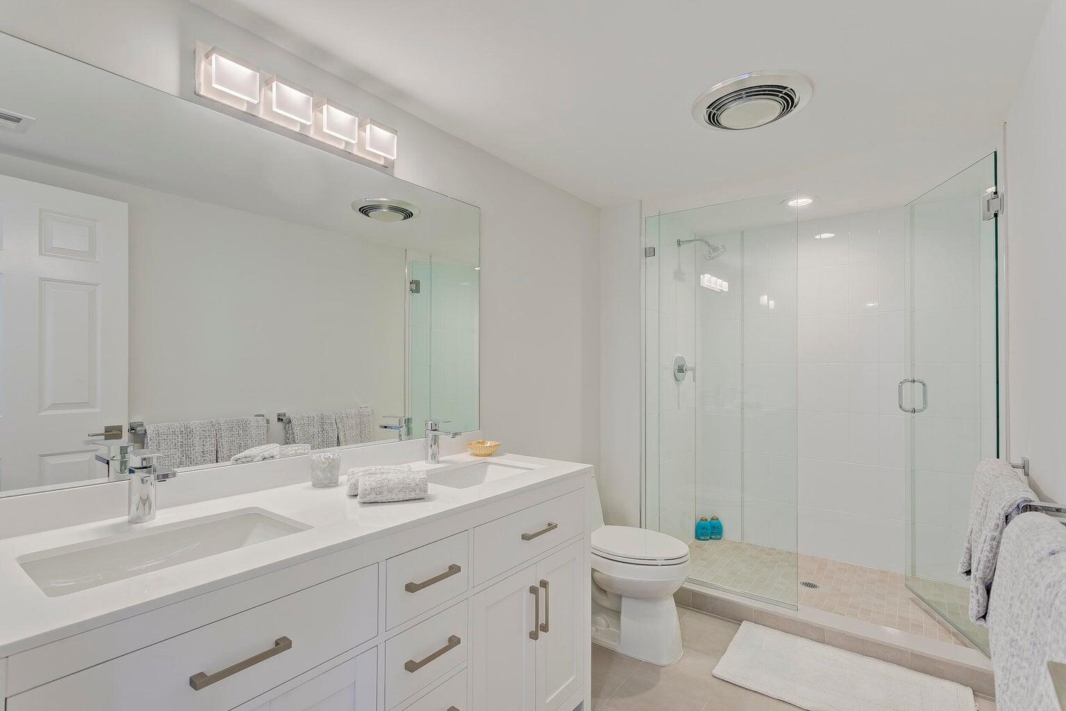 17053 Waterbend Drive, Unit 231 Jupiter, FL 33477 - Photo 17 of 26 a bathroom with a double vanity sink toilet and shower