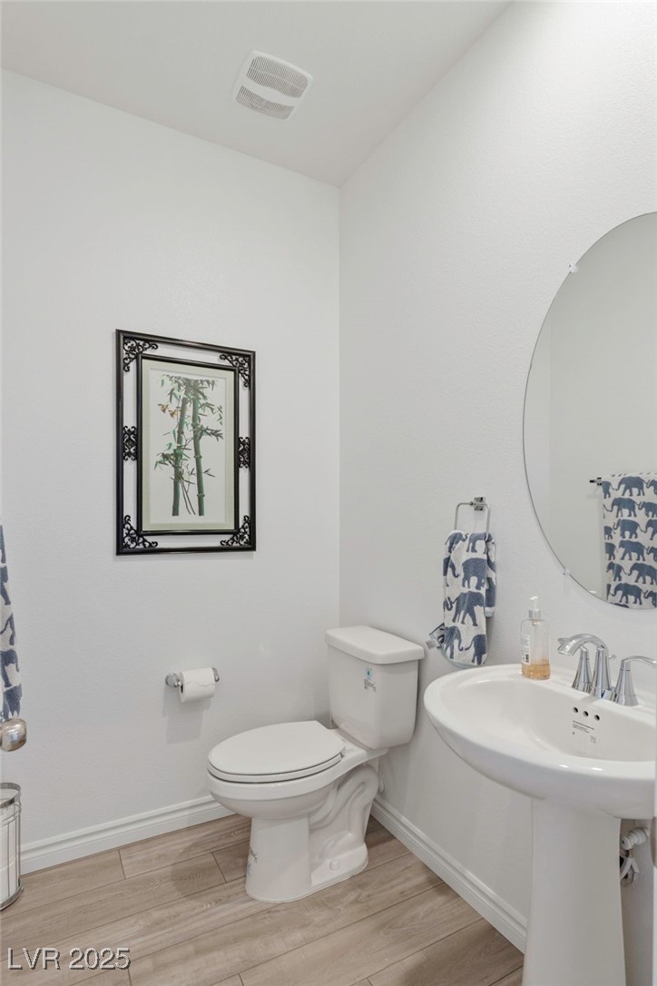 7230 North Decatur Boulevard, Unit 6 North Las Vegas, NV 89084 - Photo 10 of 27 Half bath featuring toilet and wood finished floors