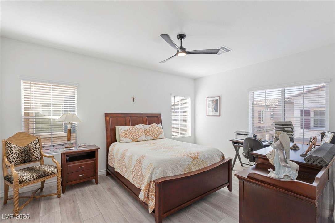 7230 North Decatur Boulevard, Unit 6 North Las Vegas, NV 89084 - Photo 11 of 27 Bedroom featuring multiple windows, light wood finished floors, and ceiling fan
