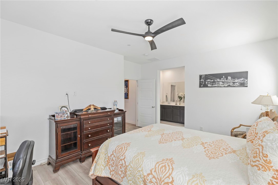 7230 North Decatur Boulevard, Unit 6 North Las Vegas, NV 89084 - Photo 12 of 27 Bedroom with light wood-style flooring, ceiling fan, and connected bathroom