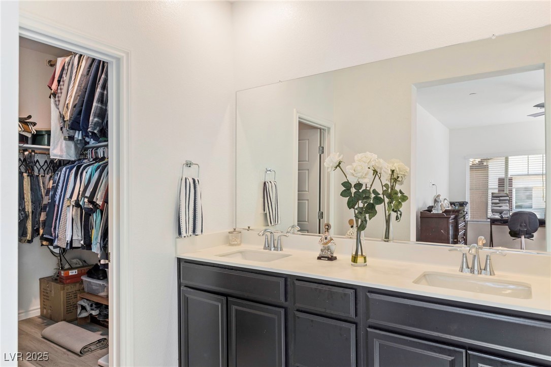 7230 North Decatur Boulevard, Unit 6 North Las Vegas, NV 89084 - Photo 13 of 27 Bathroom with double vanity, wood finished floors, and a spacious closet