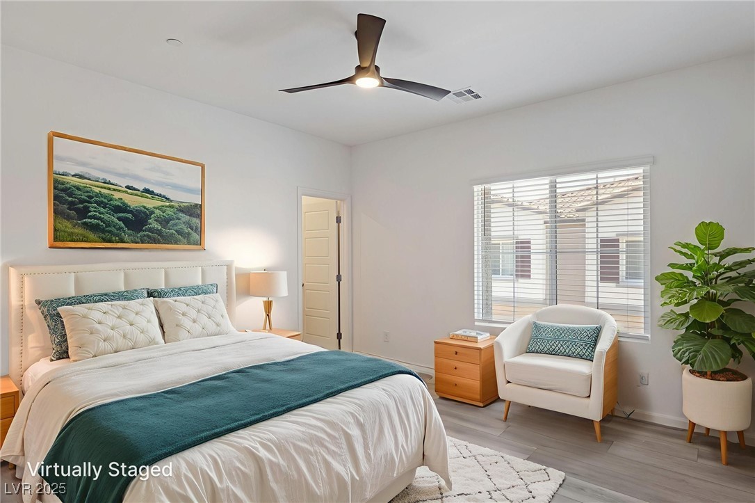 7230 North Decatur Boulevard, Unit 6 North Las Vegas, NV 89084 - Photo 16 of 27 Bedroom virtual stage with light wood-style flooring and a ceiling fan