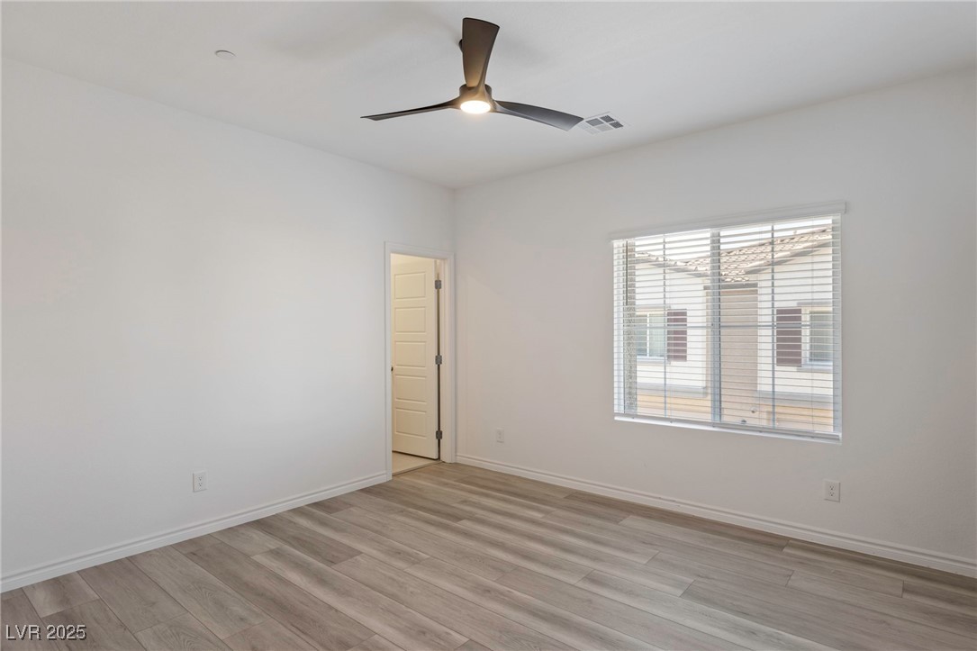 7230 North Decatur Boulevard, Unit 6 North Las Vegas, NV 89084 - Photo 17 of 27 Empty room featuring a ceiling fan and light wood-style flooring