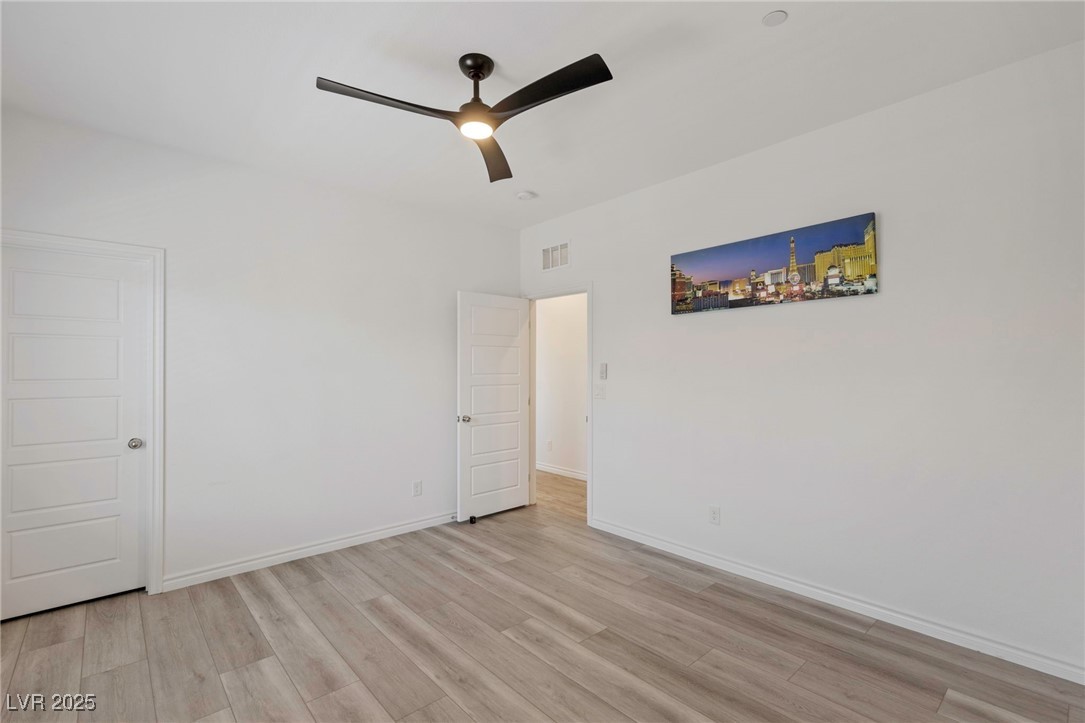 7230 North Decatur Boulevard, Unit 6 North Las Vegas, NV 89084 - Photo 18 of 27 Unfurnished bedroom with light wood-style floors and a ceiling fan