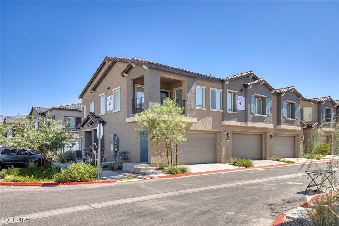 7230 North Decatur Boulevard, Unit 6 North Las Vegas, NV 89084 - Photo 2 of 27 Mediterranean / spanish home featuring stucco siding, a residential view, a garage, a tiled roof, and concrete driveway