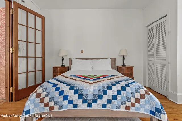 a bedroom with a bed and wooden floor