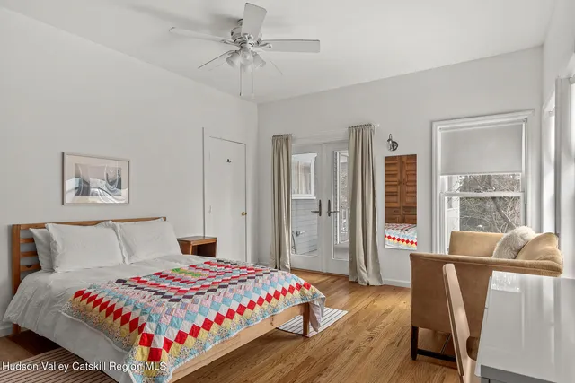 a bedroom with a large bed a chandelier and wooden floor