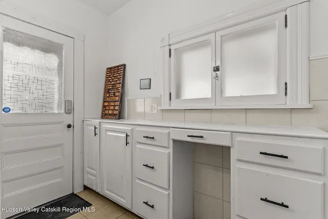 a kitchen with white cabinets and sink
