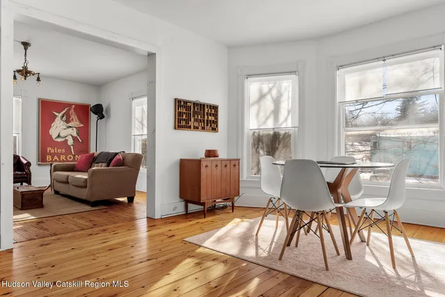 a living room with furniture a wooden floor and a large window