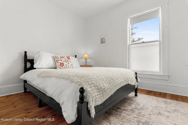 a bed sitting in a bedroom next to a window