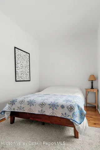 a bedroom with a bed and a lamp on dresser