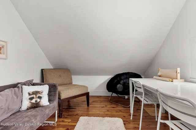 a bedroom with a chair and wooden floor