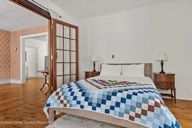 a bedroom with a bed and wooden floor