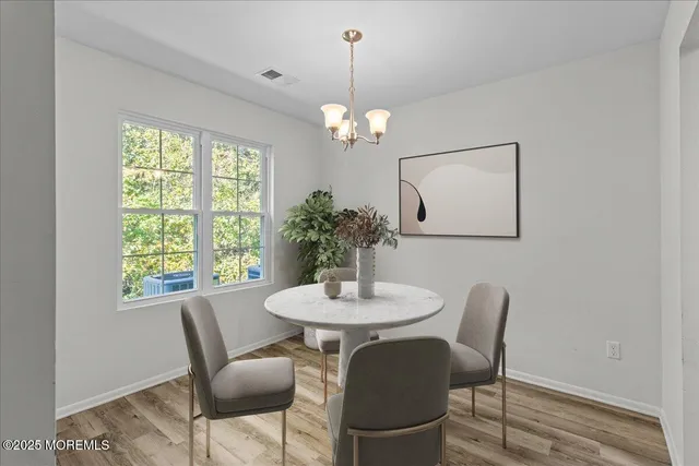 a dining room with furniture a chandelier and wooden floor