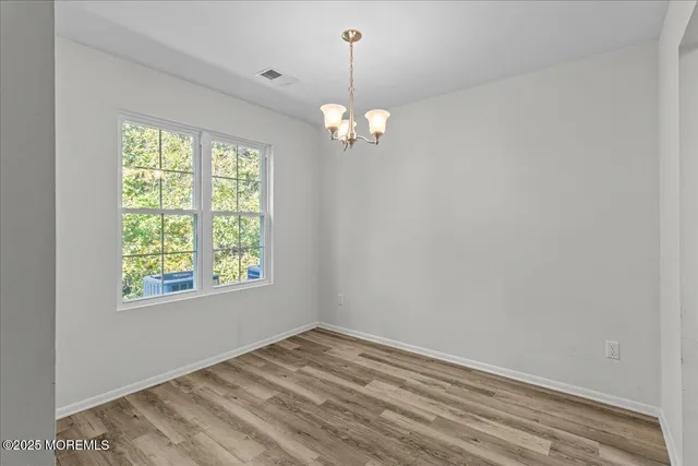 a view of a chandelier in an empty room with a window