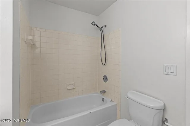 a bathroom with a shower a toilet and a shower