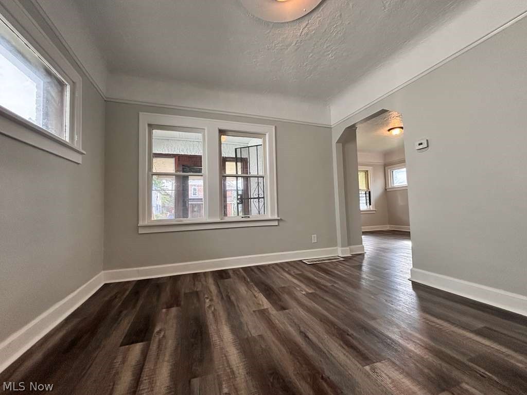 907 Rondel Road Cleveland, OH 44110 - Photo 5 of 26 Spacious room featuring wood-finish flooring, light gray walls, white baseboards, and white window trim