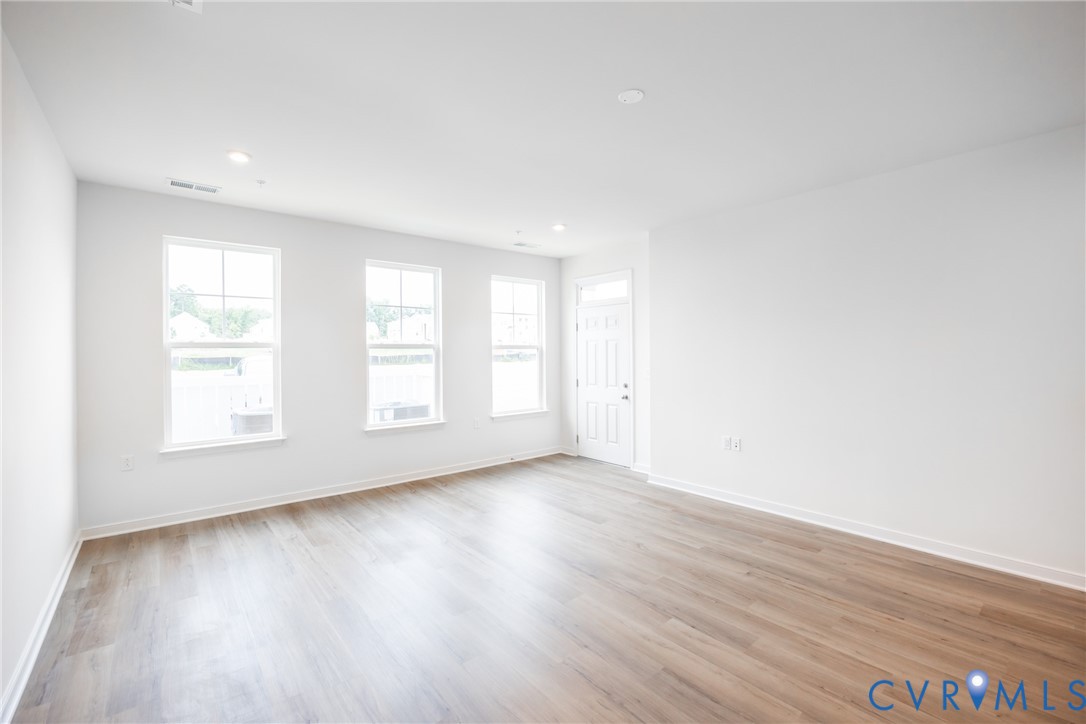 3731 Maze Runner Drive Midlothian, VA 23112 - Photo 3 of 32 an empty room with wooden floor and windows