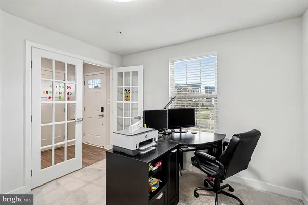 a view of a workspace with furniture and a window
