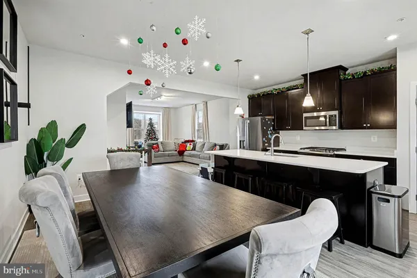 a kitchen with granite countertop a table chairs microwave and cabinets