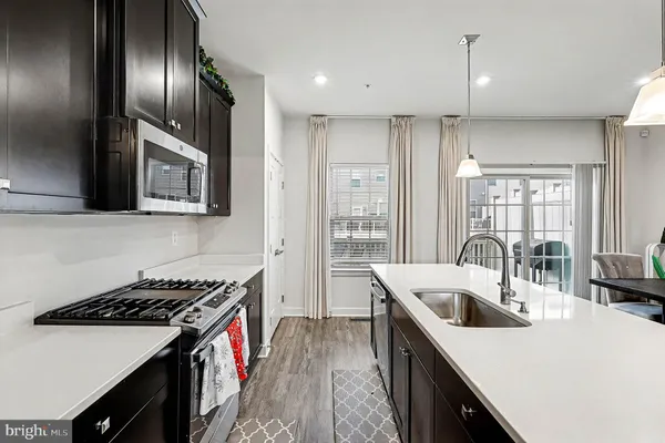 a kitchen that has a sink a stove and wooden floor
