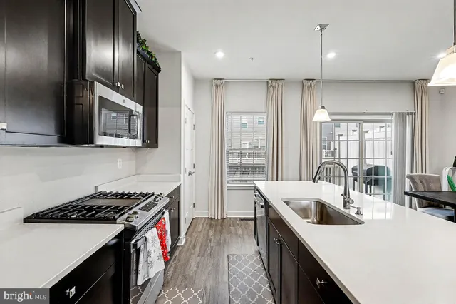 a kitchen that has a sink a stove and wooden floor