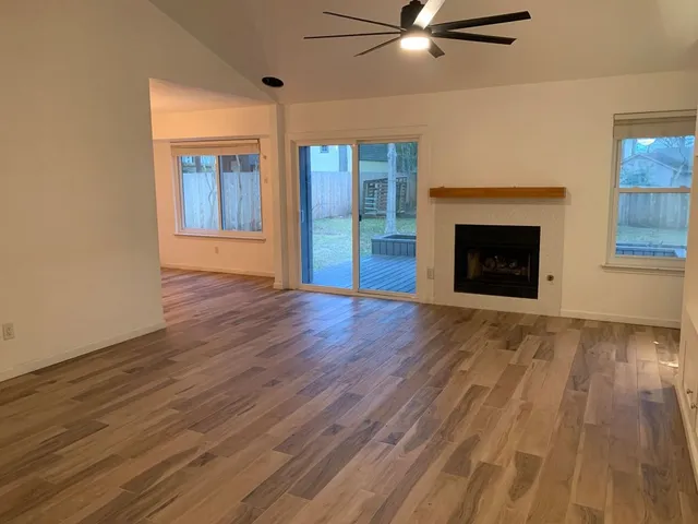 wooden floor fireplace and windows in an empty room