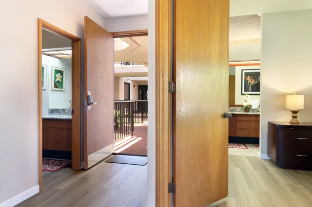 a view of a hallway with bathroom and wooden floor