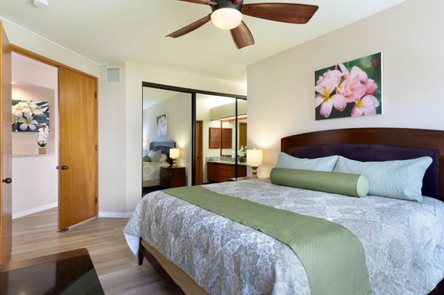 a bedroom with a large bed and a painting on the wall