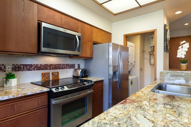 a kitchen with stainless steel appliances granite countertop a stove microwave and refrigerator