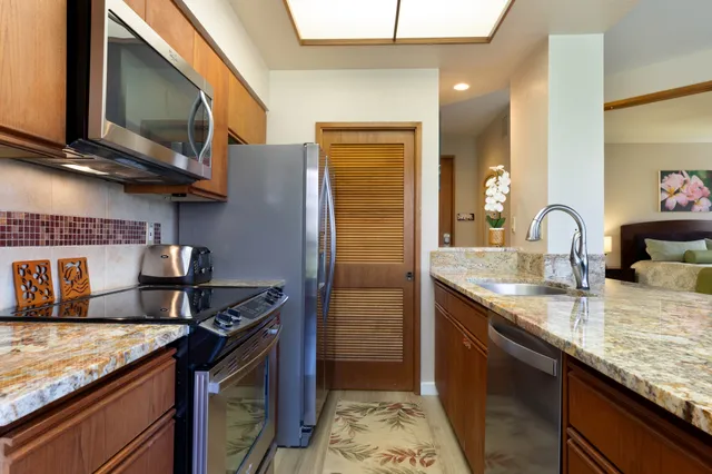 a kitchen with stainless steel appliances granite countertop a sink stove and cabinets