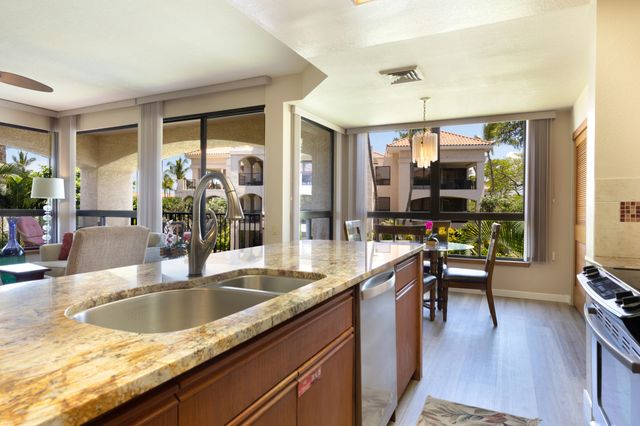 a kitchen with granite countertop a sink a counter top space and living room view