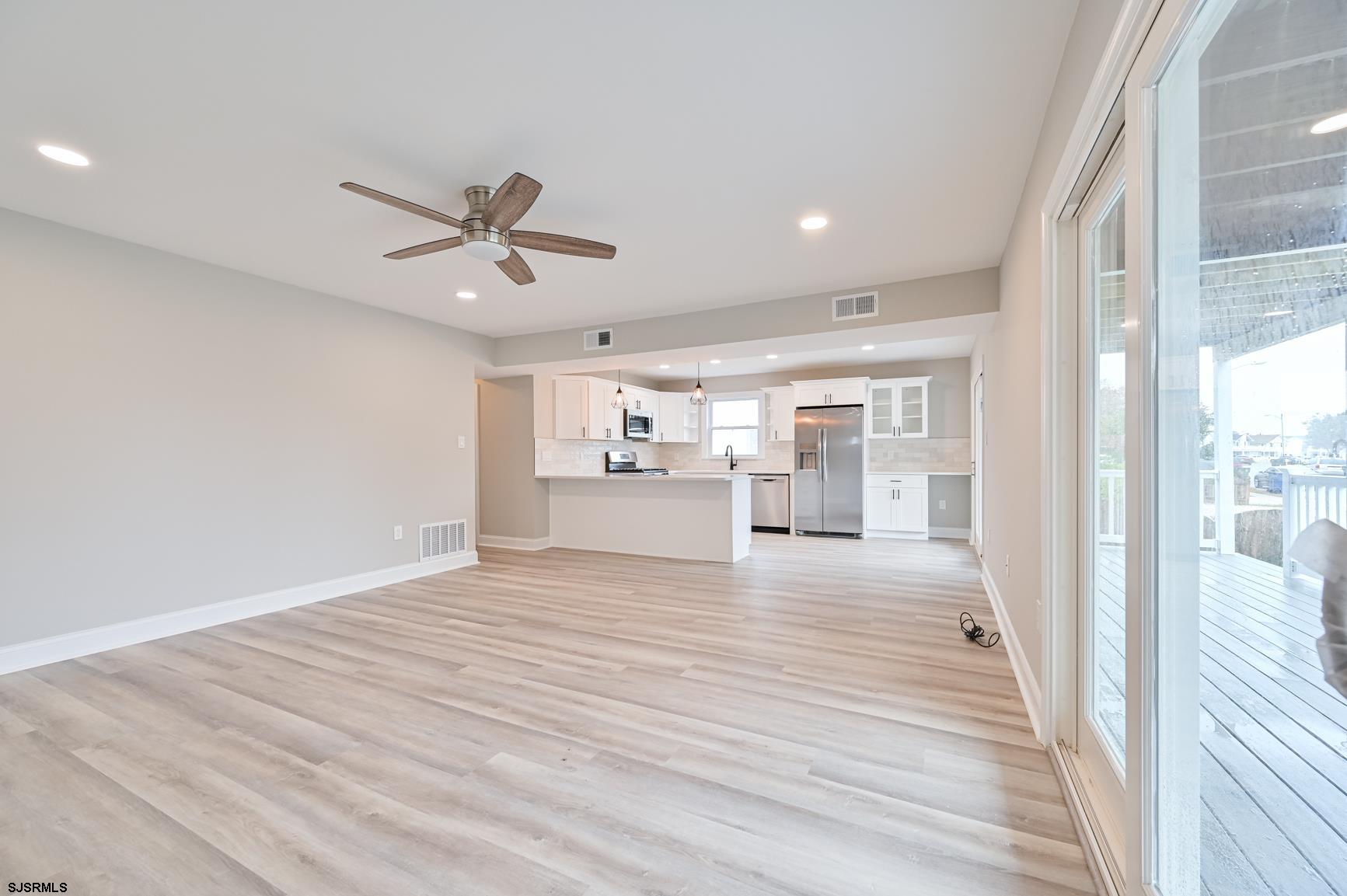 12 Lighthouse Drive, Unit A Brigantine, NJ 08203 - Photo 3 of 16 a view of a livingroom with wooden floor a ceiling fan and windows