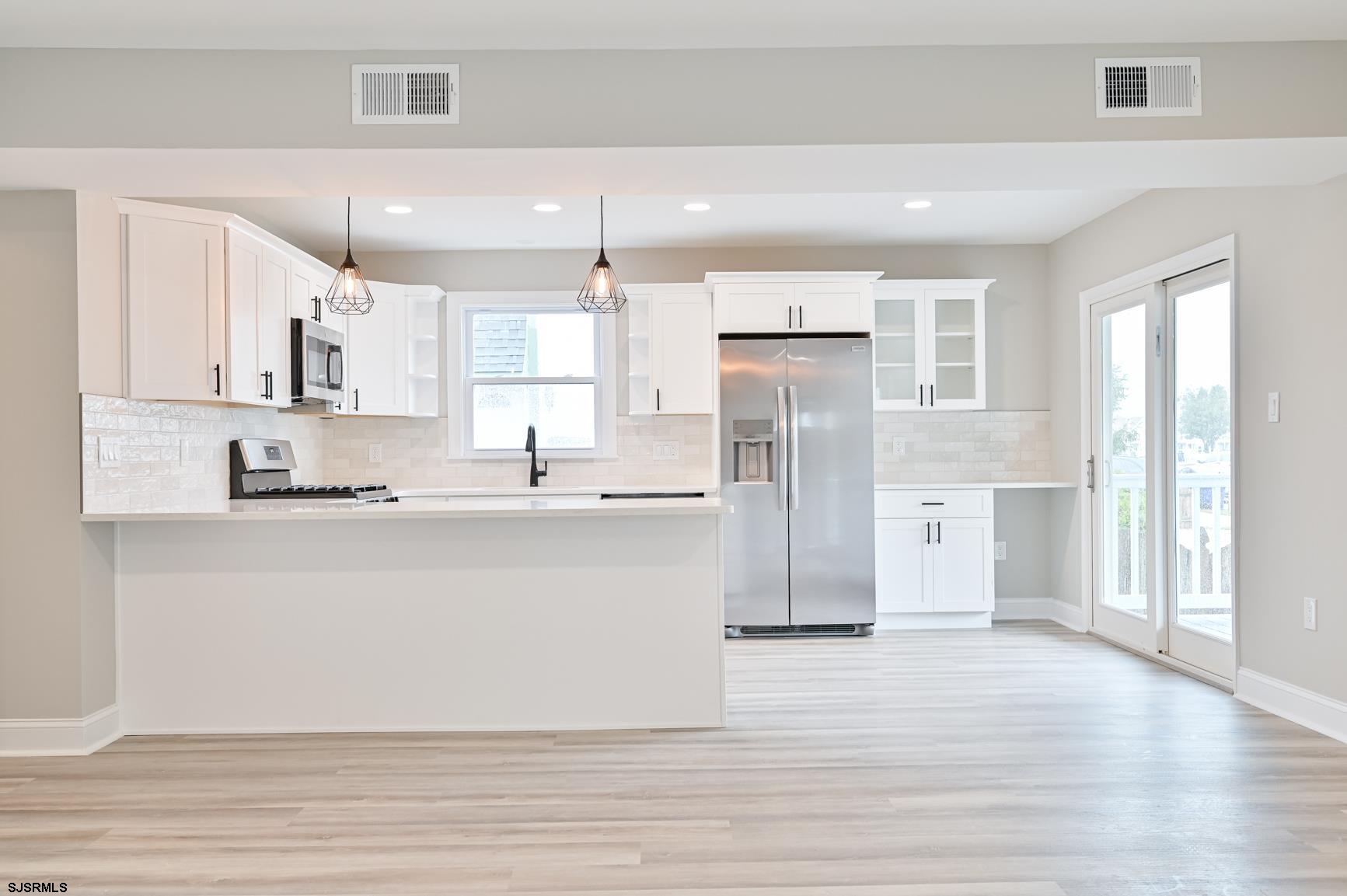 12 Lighthouse Drive, Unit A Brigantine, NJ 08203 - Photo 5 of 16 a view of kitchen with stainless steel appliances refrigerator stove microwave and cabinets