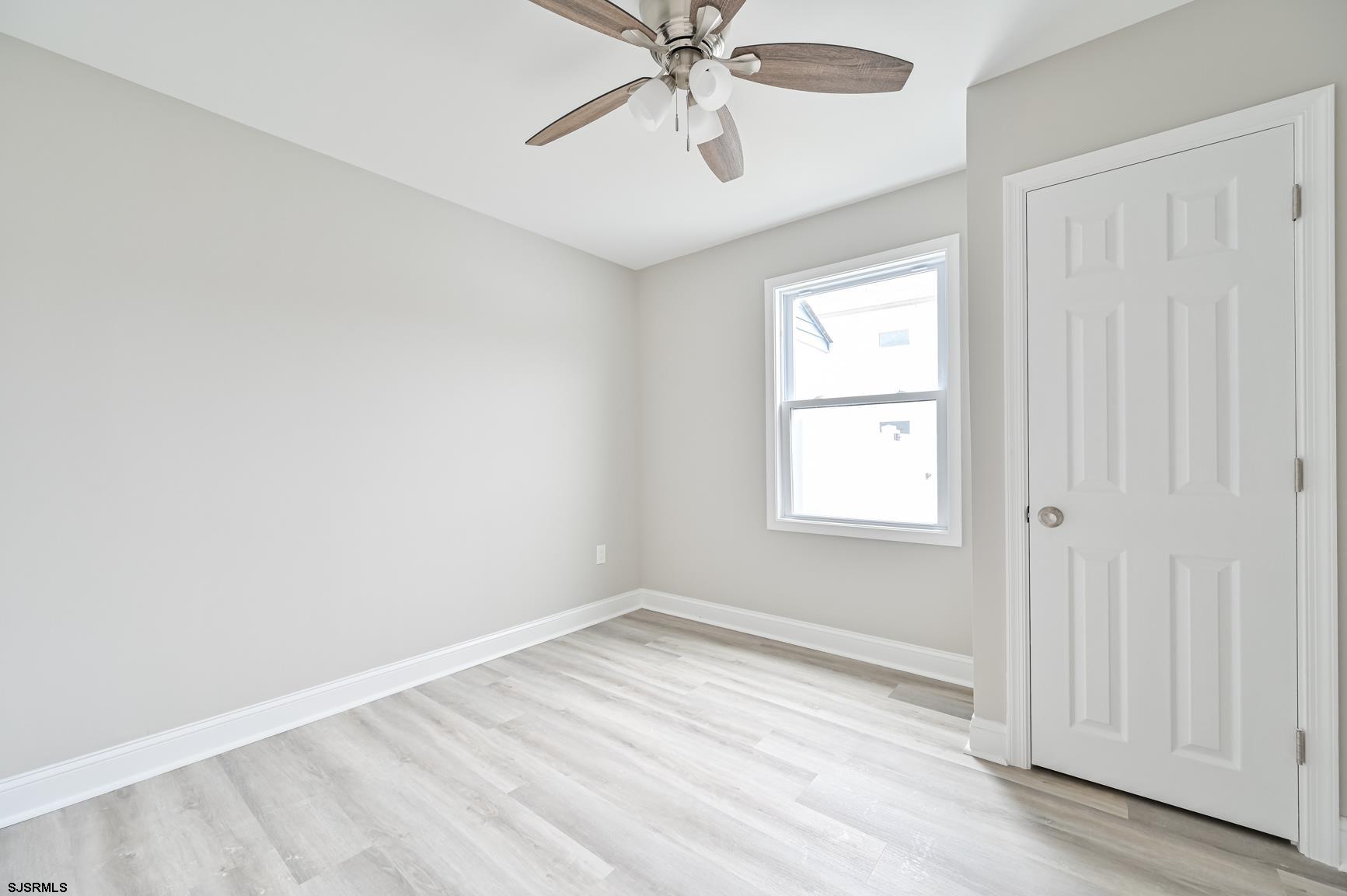 12 Lighthouse Drive, Unit A Brigantine, NJ 08203 - Photo 9 of 16 wooden floor in an empty room with a window