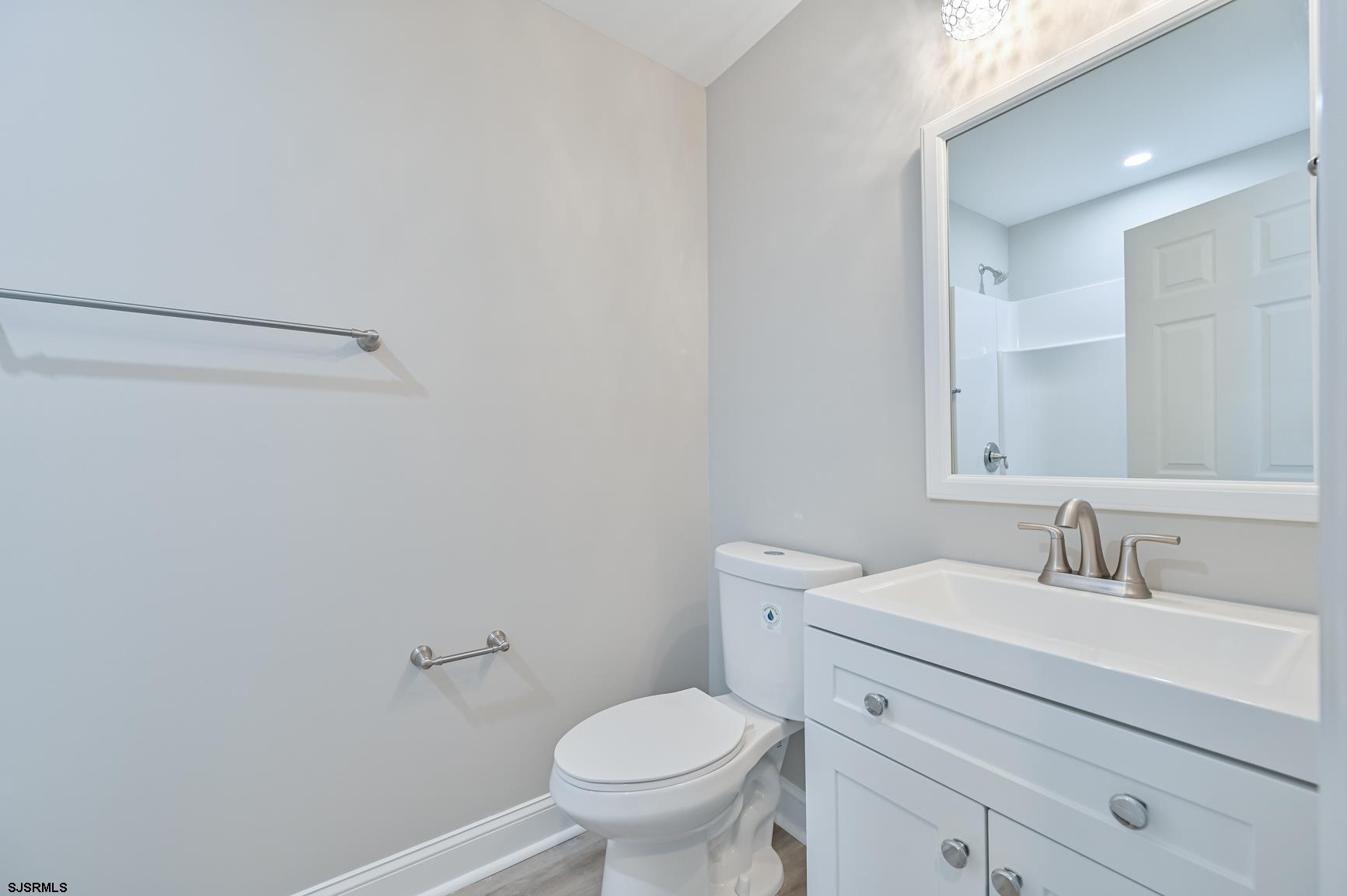 12 Lighthouse Drive, Unit A Brigantine, NJ 08203 - Photo 10 of 16 a bathroom with a toilet sink and mirror