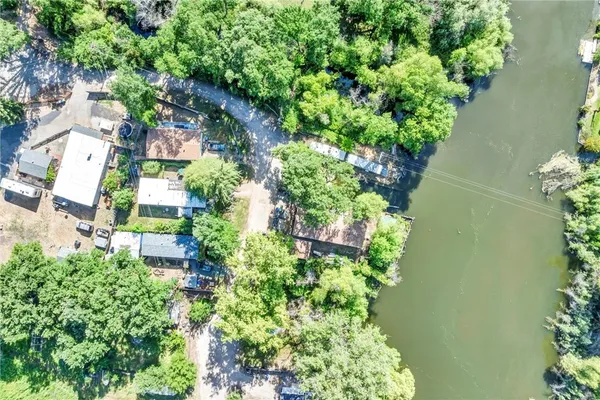 an aerial view of residential house with outdoor space and trees all around