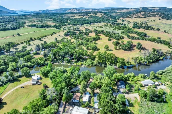 an aerial view of residential houses with outdoor space and trees