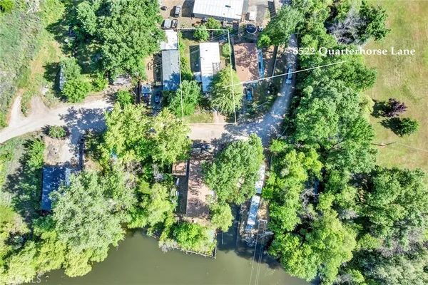 an aerial view of residential house with outdoor space and trees all around